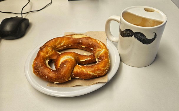 Teller mit Butterbrezel, daneben eine Kasse Taffee oder so... 